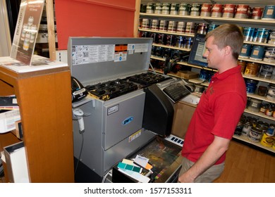 BATTLE LAKE, MINNESOTA / USA - JULY 05, 2017: Hardware Store Employee Combining Just The Right Tints Of Paint In An Electronically Guided Mixing Machine. 