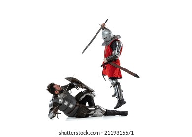 Battle Portrait Of Two Men Fighting, Medieval Warror Attacking With Sword Another Knight Isolated Over White Studio Background. Serious Battle, Fight. Comparison Of Eras, History, Renaissance