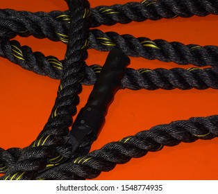 Battle Rope On Orange Floor After Workout Without People, Close-up Of Black Battle Rope