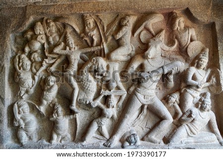 Battlefield scene of Hindu Goddess Durga fight with the Buffalo headed Demon with her army of female warriors is carved as Bas relief sculpture in the rock cut cave temples in Mahabalipuram, Tamilnadu