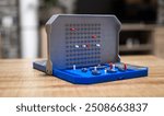 A battleship game on a table indoors. Nice soft background.