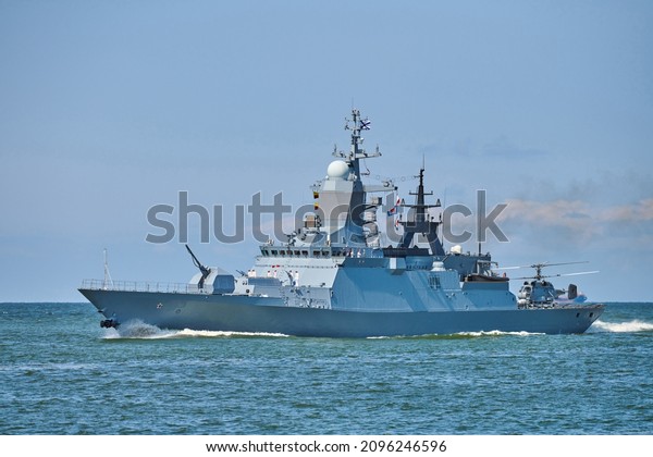 Battleship war ship corvette with helicopter on deck\
performing military exercises in Baltic Sea. Warship boat carrying\
helicopter sailing in beautiful blue sea. Military warship, Russian\
Navy