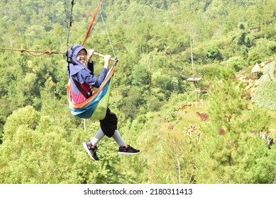 Batu, Indonesia - June 21, 2018 : A Girl Is Enjoying The Activity Of Flying Fox At A Tourist Spot.