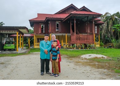 Batu Pahat, Malaysia - May 3rd, 2022 :  Happy Malay Family In Traditional Clothing And Traditional Malay House During Hari Raya. Malaysian Family Lifestyle At Home. Happiness Concept.