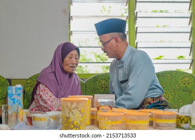 Batu Pahat, Malaysia - May 3rd, 2022 :  Happy Malay Family In Traditional Clothing And Traditional Malay House During Hari Raya. Malaysian Family Lifestyle At Home. Happiness Concept.