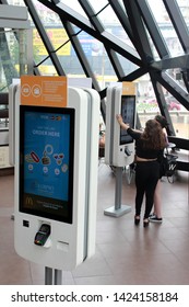 Batumi, Georgia - June 2019: Two Dark-haired Girls Are Purchasing Fast Food From The Online Self Service McDonalds Terminal.