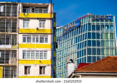 Batumi, Georgia - May 12, 2022: Exterior Of Shabby Apartment Building And Modern Hotel With Glass Walls Located Against Blue Sky On Sunny Day On Street Of Batumi, Georgia