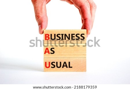 BAU business as usual symbol. Concept words BAU business as usual on wooden blocks on a beautiful white background. Businessman hand. Business and BAU business as usual concept. Copy space.