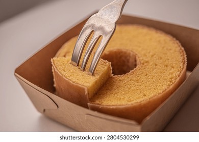 Baumkuchen ring cake with fork in paper box close up traditional Japanese German dessert