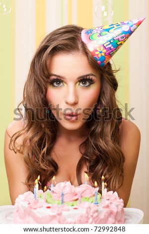 bautiful caucasian girl blowing candles on her cake