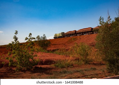 Bauxite Clay Open-cut Mining. Cargo Train With Aluminium Ore. Blue Sky Background. Evening Light On Sunset