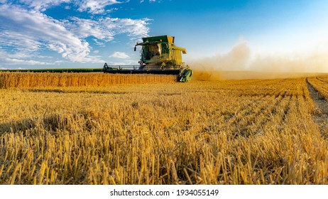 Bavaria, Germany-July 2018: View of agricultural wheat field during harvest time with industrial combine machine in working prosses. Countryside crops of Bavarian environment. 