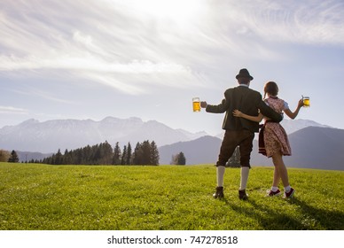 Bavarian couple in traditional clothes holding beer mug in hand, Bavaria Germany. Bavarian couple celebrating Oktoberfest from Munich Germany Bavaria