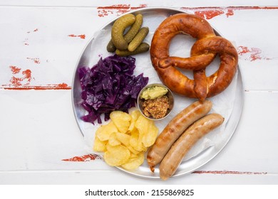 Bavarian Dish Sausage With Pretzel, Mustard, Braised Red Cabbage, Pickles And Potato Chips