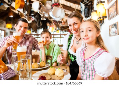 Bavarian Family Having Traditional Meal In German Restaurant 