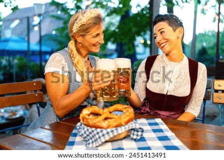 Similar – Image, Stock Photo Female waiter in tracht, Dirndl serving food in Bavarian beer garden, people eating and drinking toasting beer muds in background