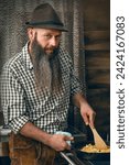 A bavarian man in a kitchen cooking a traditional meal