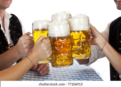 Bavarian Men And Women Toast With Oktoberfest Beer Stein. Isolated On White Background.