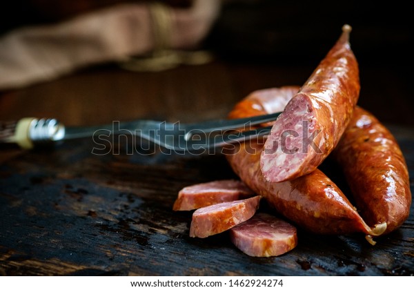 Bavarian smoked sausages from pork cut on a wooden\
Board. Rustic style