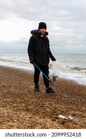 Bawdsey, Suffolk, UK January 06 2021: An Adult Male Doing A Beach Clean And Picking Up Litter And Discarded Rubbish. Litter Pick, Environmental, Beach Clean Concept