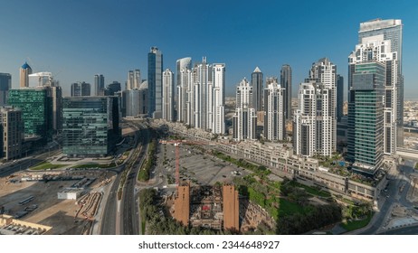 Bay Avenue during sunrise with modern towers residential development in Business Bay aerial panoramic, Dubai, UAE. Skyscrapers with sun reflected from glass and long shadows