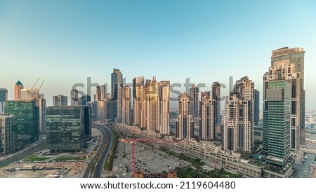 Bay Avenue during sunrise with modern towers residential development in Business Bay aerial panoramic timelapse, Dubai, UAE. Skyscrapers with sun reflected from glass and long shadows