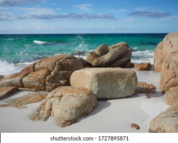 Bay of Fires Tasmania Sloop Bay with orange lichen on the rocks and beautiful turquoise water.   Wave spraying over the rocks       - Powered by Shutterstock