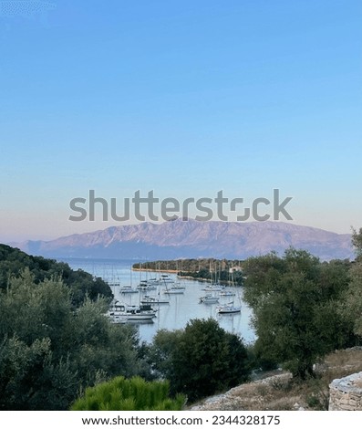 Bay full of sailing boats in the Mediterranean, mountains in background, blue bay