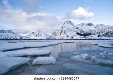 The bay, surrounded by snowy mountains and dotted with ice formations. The magic of nature in its frozen splendor. Unique juxtaposition of ice and sea - Powered by Shutterstock