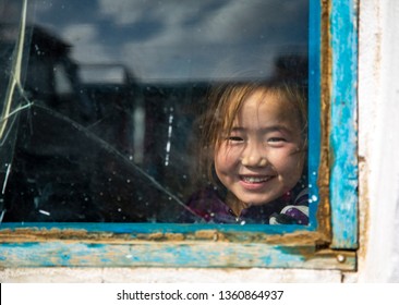 Bayan Ulgii, Mongolia, 28th September 2015: Mongolian Kids Looking Out Of A Broken Window