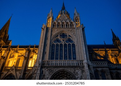 Bayeux Cathedral illuminated at dusk, showcasing Gothic architecture and intricate stonework. Captures the majestic beauty and historic significance of this iconic landmark in Normandy, France. - Powered by Shutterstock