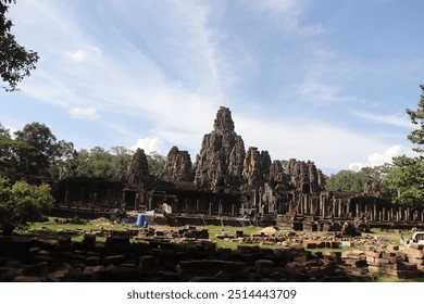 Bayon Temple's towering stone faces gaze serenely in all directions, intricately carved into massive blocks. The temple's maze-like corridors evoke mystery amidst ancient Cambodian jungle. - Powered by Shutterstock