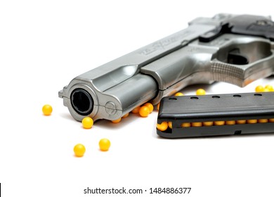 BB Gun, Old Airsoft Pistol Toy and Magazine with BB Gun Bullets on White Background.