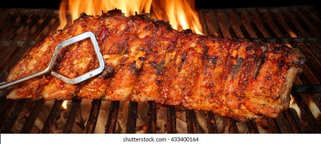 BBQ  Baby Back Or Spareribs Ribs Close-up On The Hot Flaming Grill