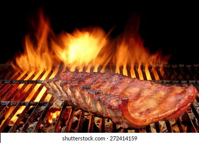 BBQ Baby Back Spicy Marinated And Smoked Pork Ribs On The Hot Charcoal Grill With Bright Flames On Black Background. Good Snack For Outdoor Party Or Picnic