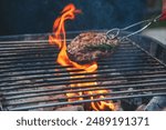 BBQ Barbecue grilled meat stick on fire flame with hot charcoal cooking outside. Beef grilling picnic outdoor with smoke bacon spicy sausage for party. Grill pork bbq on fire flame