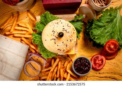 BBQ Beef Cheese burger with french fries, potato and tomato slice isolated on wooden board top view on table fast food