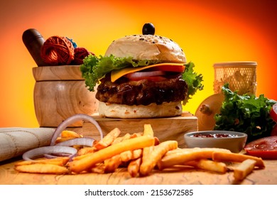 BBQ Beef Cheese burger with french fries, potato and tomato slice isolated on wooden board side view on table fast food