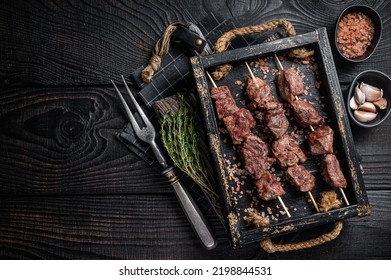 BBQ Beef veal shish kebab Skewers. Black background. Top view. Copy space.