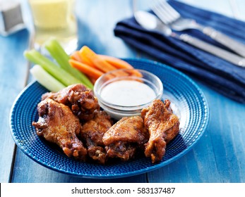 Bbq Buffalo Chicken Wings On Blue Plate With Ranch Dip And Celery Sticks