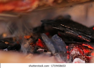 BBQ: Charcoal And Wood Chips On Fire Smoking A Piece Of Beef