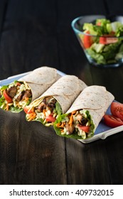 BBQ chicken with fresh salad tortilla wraps on rustic background