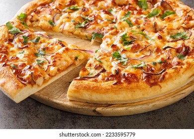 BBQ Chicken Pizza made with barbecue sauce, mozzarella, chicken, red onions and cilantro on perfect homemade pizza crust closeup on the wooden board on the table. Horizontal - Shutterstock ID 2233595779