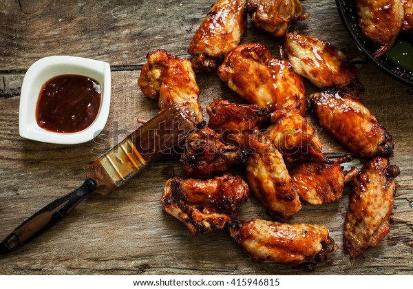 BBQ chicken wings with\
sauce for dip