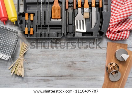 BBQ cooking set in the case on the wood background.