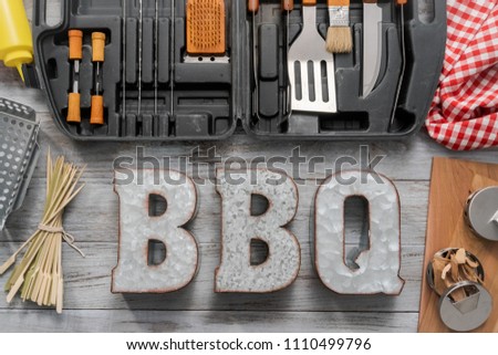 BBQ cooking set in the case on the wood background.