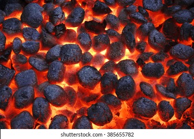 BBQ Grill Pit With Glowing And Flaming Hot Charcoal Briquettes, Food Background Or Texture, Close-Up, Top View