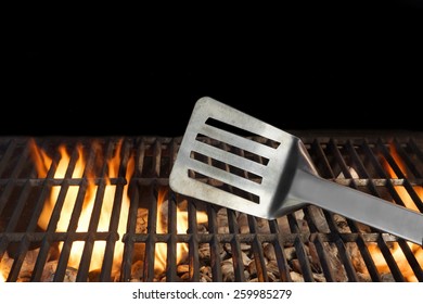 BBQ Grill And Spatula. Flame Of Fire In The Background.