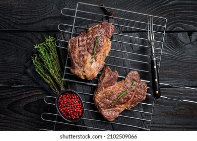 BBQ Grilled Chuck Eye Roll Beef Steaks On Grill. Black Wooden Background. Top View