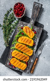 BBQ Grilled Halloumi Cheese With Arugula On Wooden Board. Gray Background. Top View.